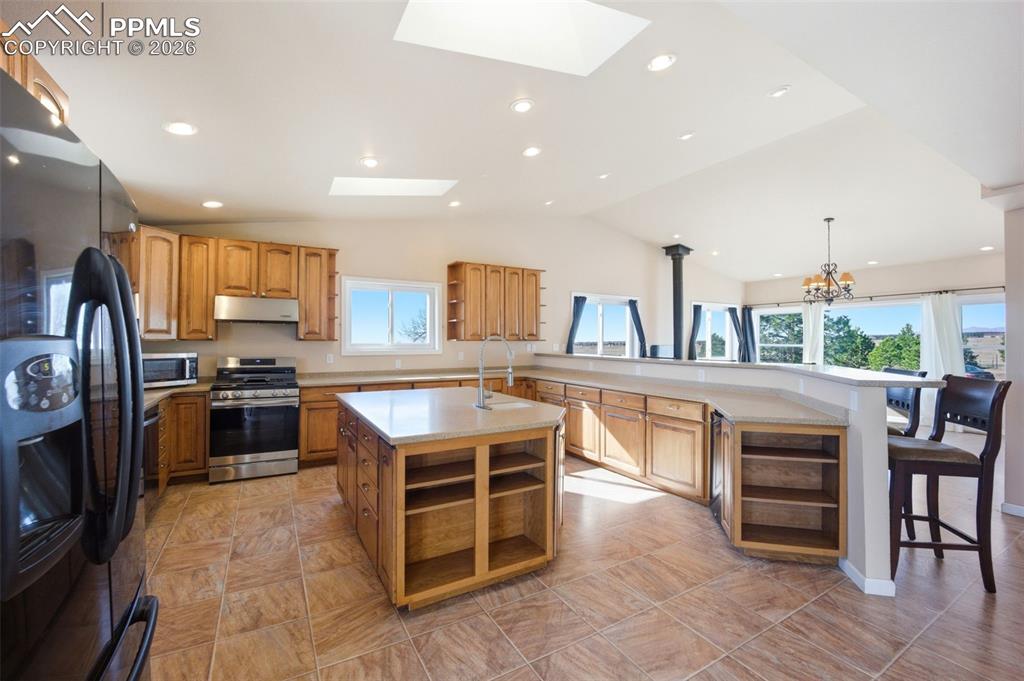 Image 4 of 50: Kitchen with high end wood cabinets, Corian countertops, 2 skylights, large