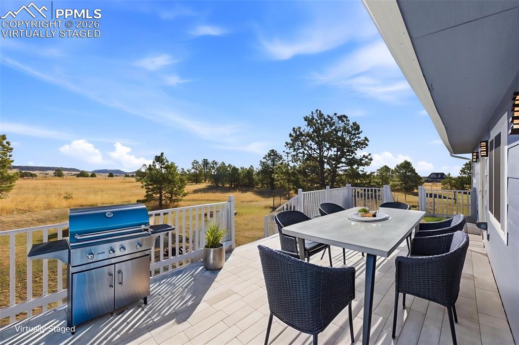 Image 41 of 50: Virtually staged deck with outdoor dining area, a patio area, area for gril