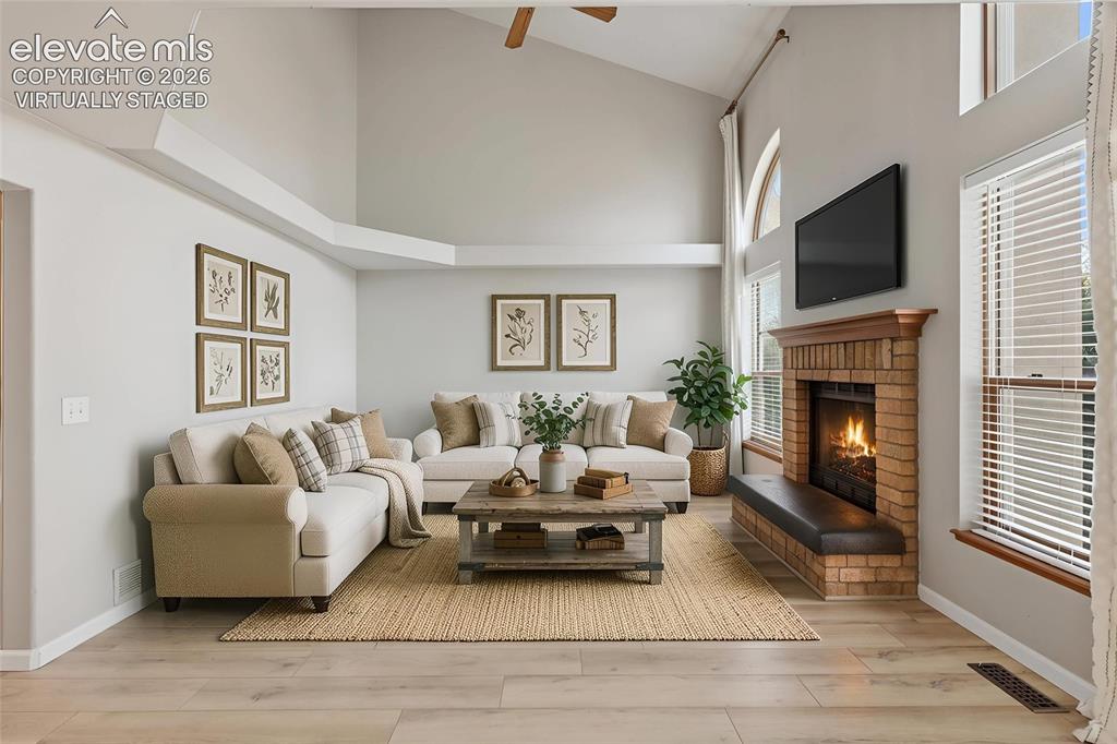 Image 17 of 50: Virtually staged. Vaulted ceilings, wood-finish flooring, brick fireplace w