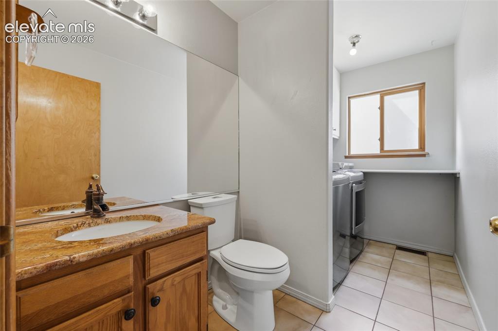 Image 20 of 50: main level half-Bathroom featuring a wood-finish vanity with an integrated 
