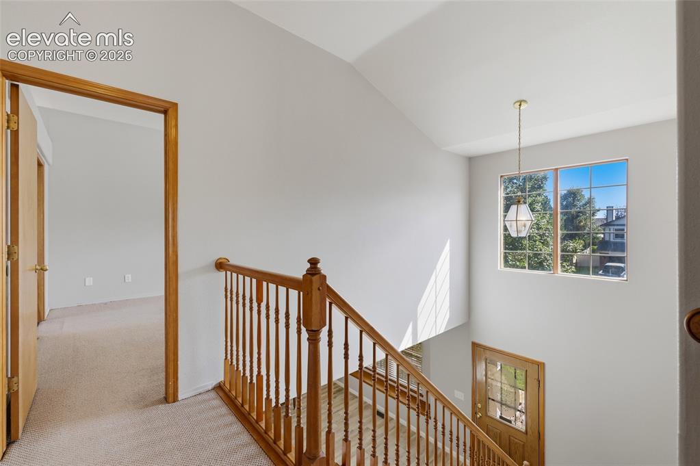 Image 22 of 50: Wood-finish staircase with turned spindles and a matching handrail.  Entry 