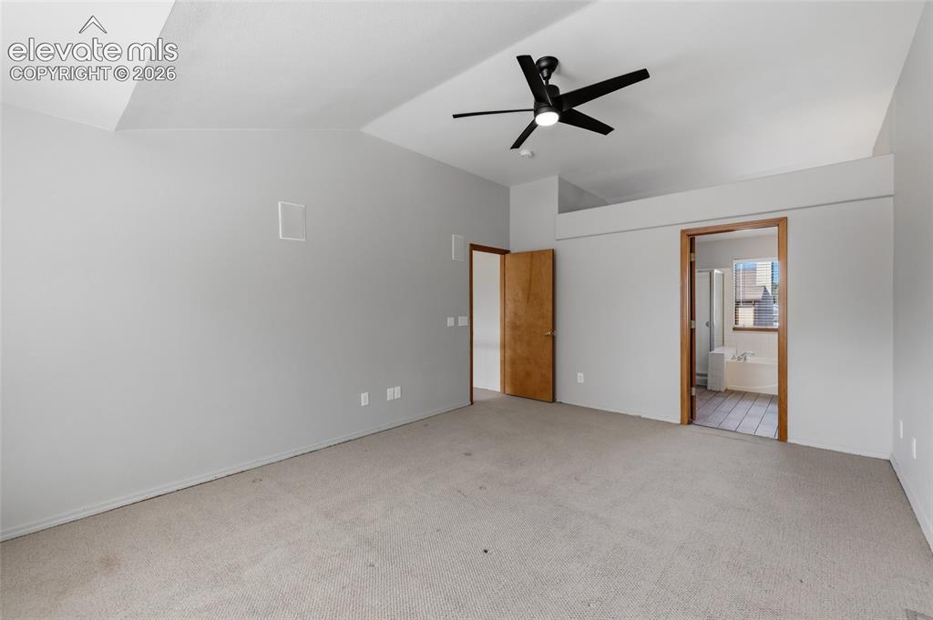 Image 26 of 50: Vaulted ceiling with a black ceiling fan, light gray wall finish, and neutr