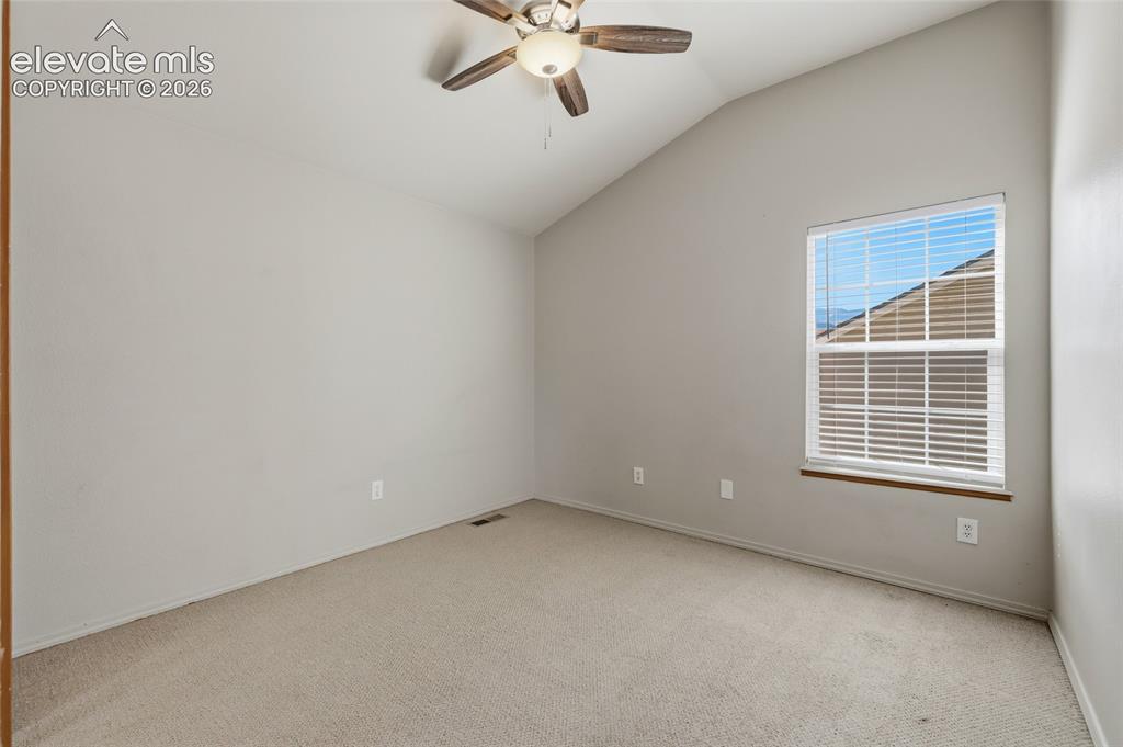 Image 31 of 50: Vaulted ceiling with an integrated ceiling fan, carpeted flooring, and a si