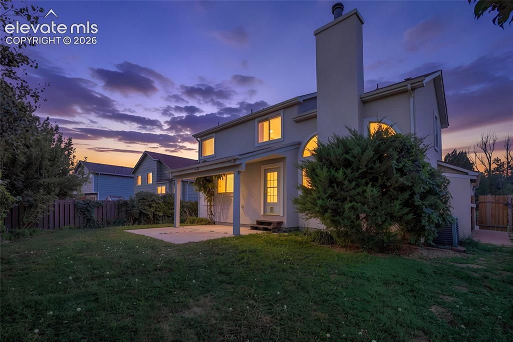 Image 45 of 50: Expansive backyard with a concrete patio, covered porch, and privacy fencin