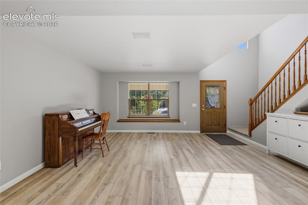 Image 7 of 50: Wood-finish flooring throughout, featuring a natural wood staircase with ba