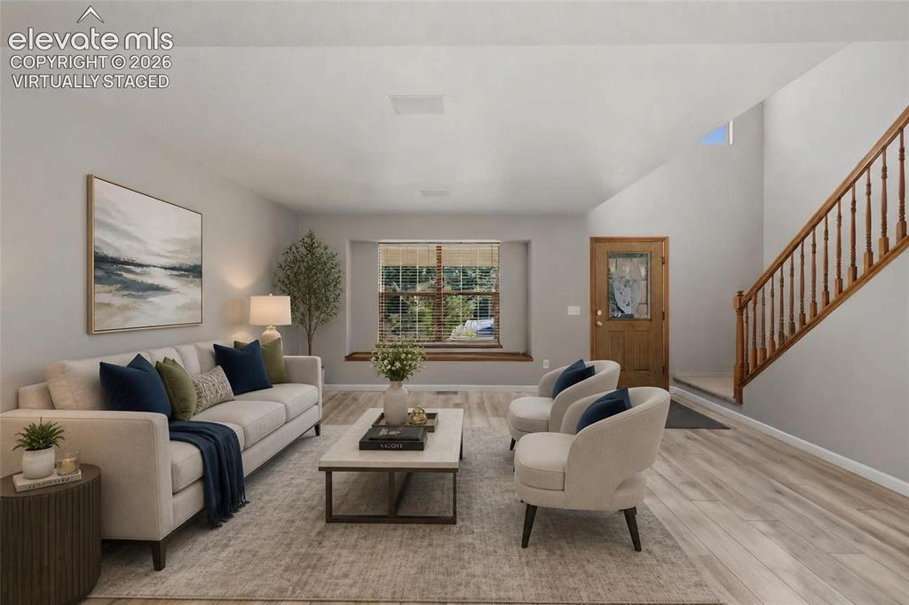 Image 8 of 50: Virtually staged.  Bright living space featuring wood-finish flooring, a wi