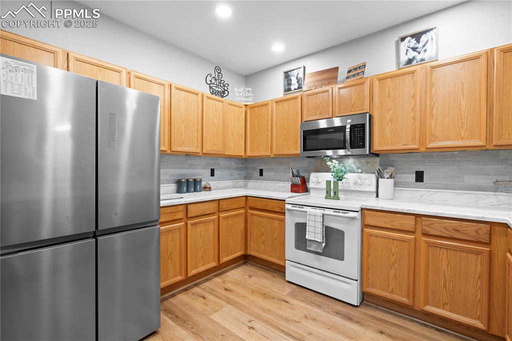 Image 11 of 29: Kitchen with appliances with stainless steel finishes, tasteful backsplash,