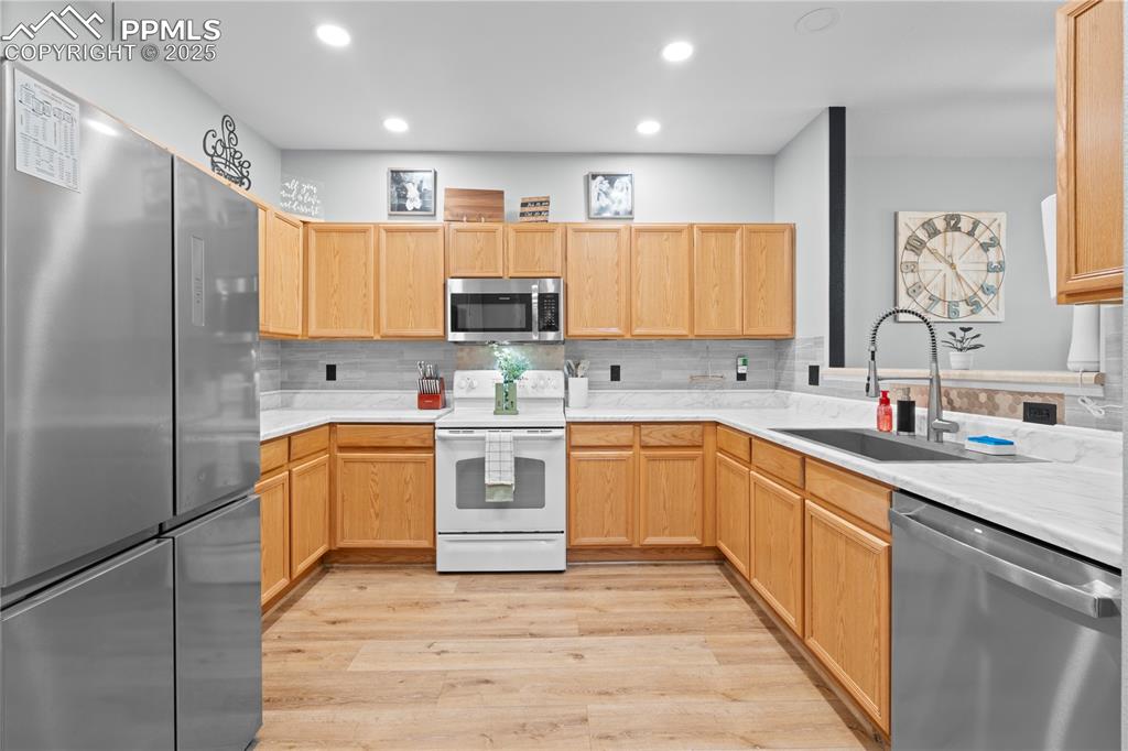 Image 12 of 29: Kitchen featuring stainless steel appliances, light wood-style flooring, li