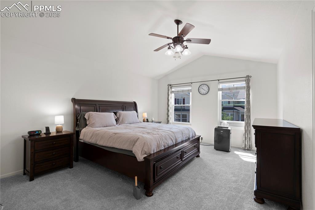 Image 21 of 29: Bedroom with carpet floors, lofted ceiling, and a ceiling fan