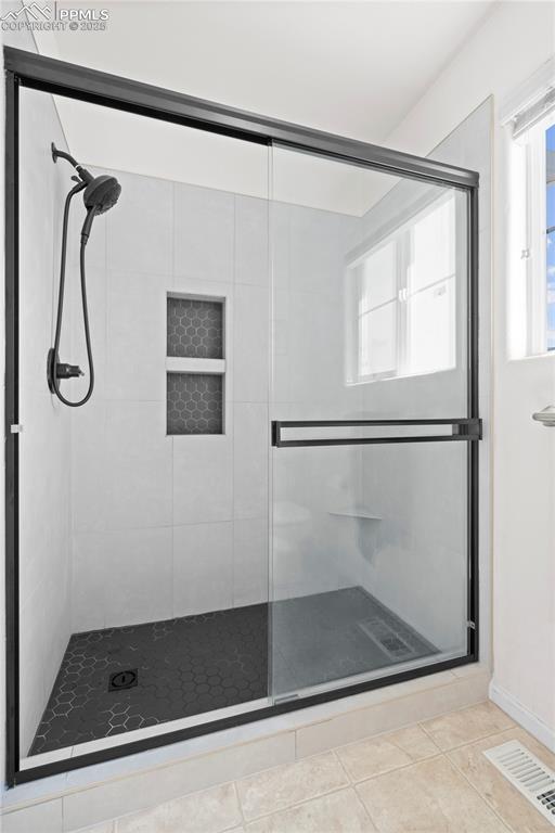 Image 26 of 29: Full bathroom with a stall shower and tile patterned floors