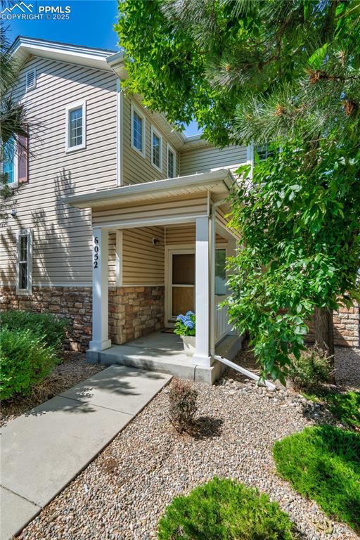 Image 28 of 29: View of front facade featuring a porch and stone siding