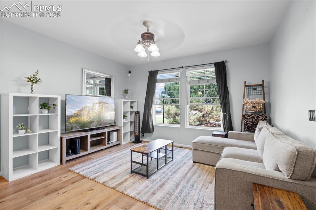 Image 4 of 29: Living room featuring ceiling fan and wood finished floors