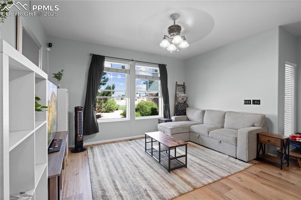 Image 5 of 29: Living area featuring wood finished floors and a ceiling fan