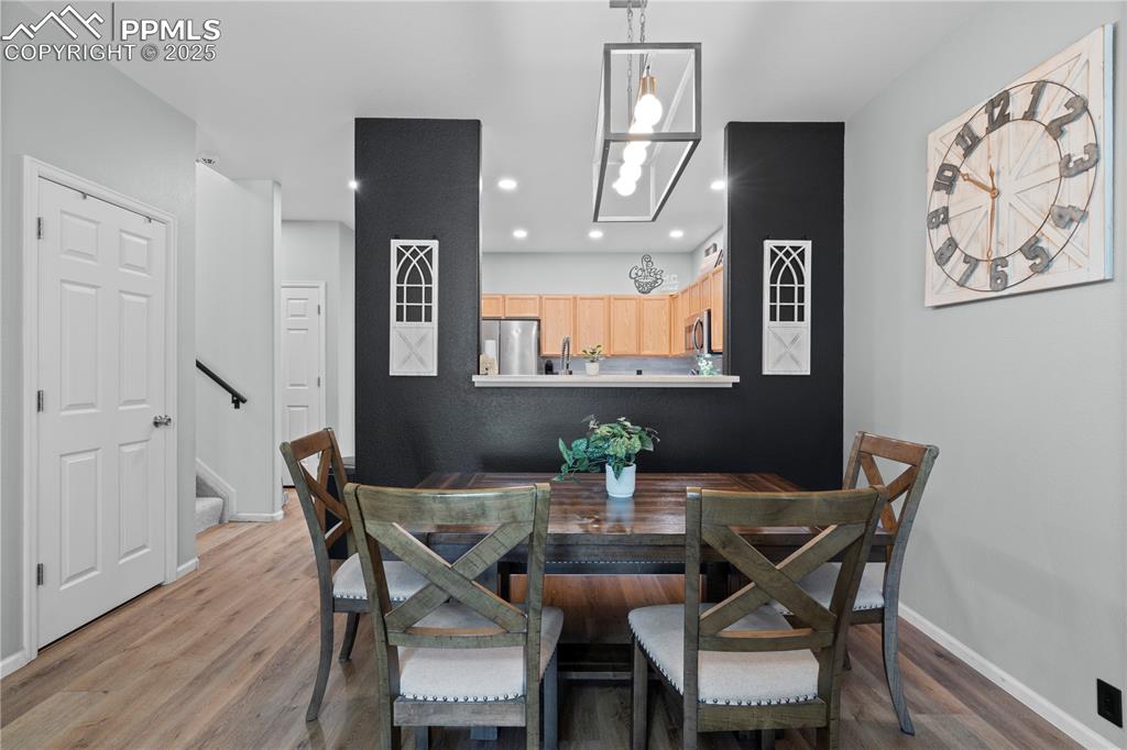 Image 8 of 29: Dining area featuring wood finished floors, recessed lighting, and stairs