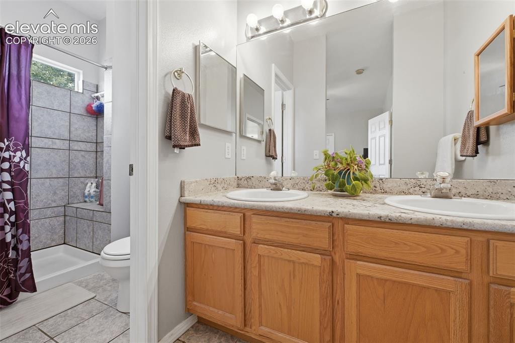 Image 14 of 31: Master bathroom with two sinks, granite counters and private shower/toilet