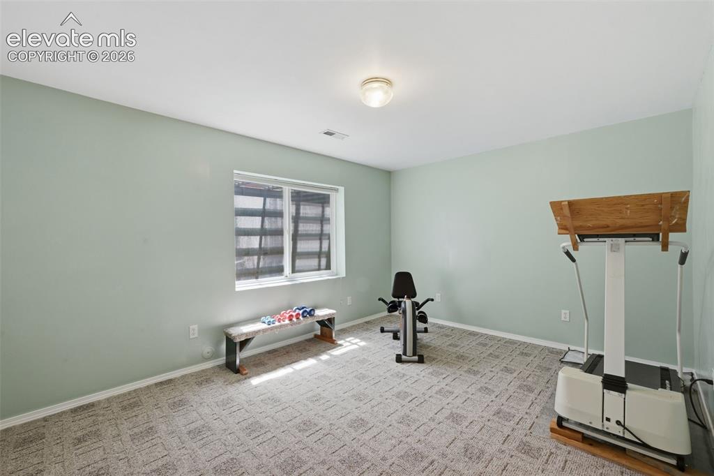 Image 20 of 31: Third bedroom in the basement being used as a work out room