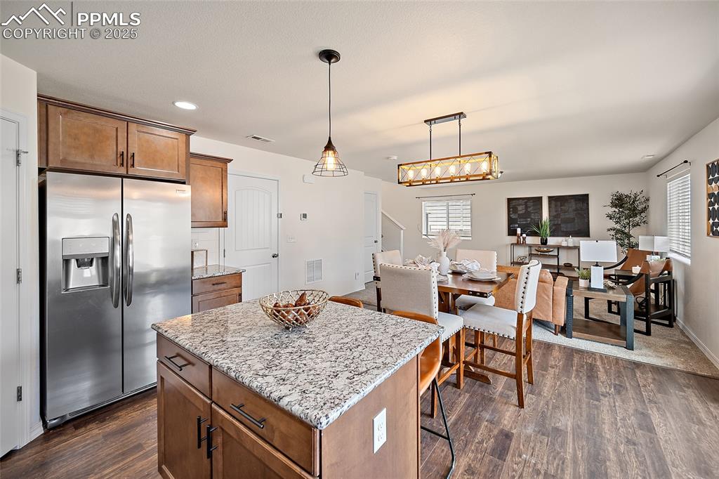 Image 19 of 50: Kitchen featuring stainless steel fridge, dark wood-type flooring, light st