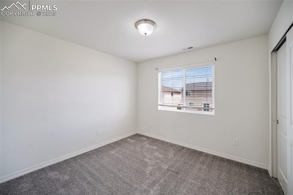 Image 23 of 50: Empty room featuring carpet flooring and baseboards