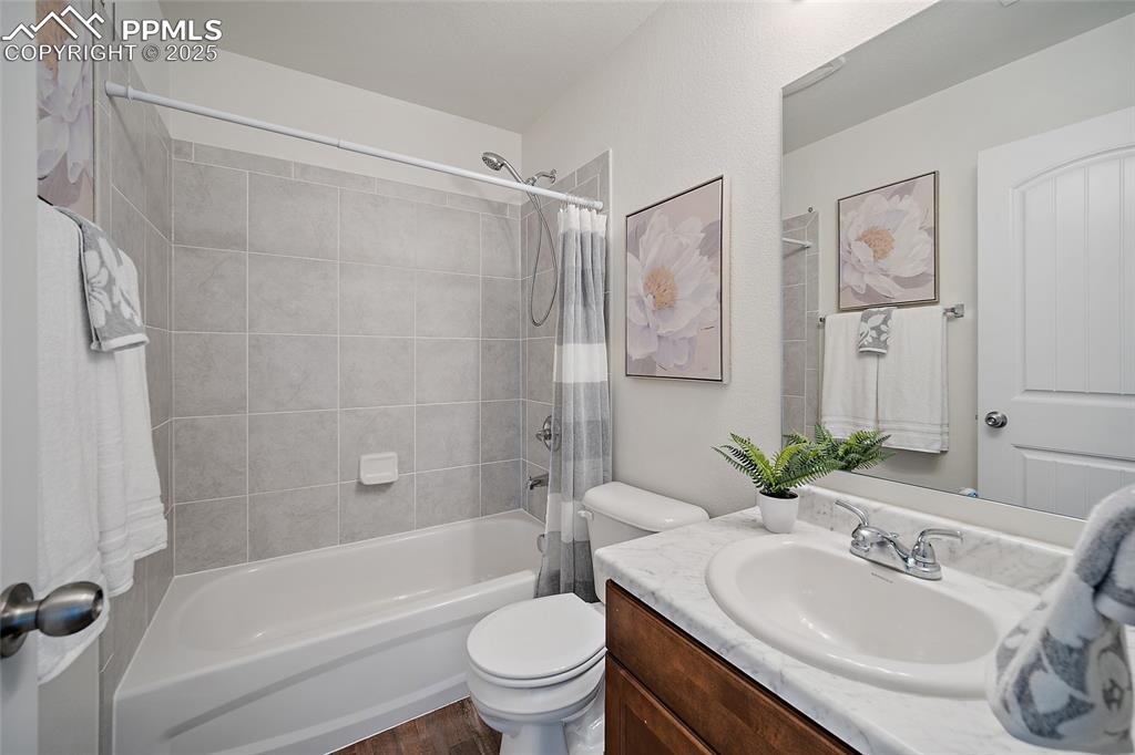 Image 26 of 50: Bathroom with shower / bath combo with shower curtain, vanity, and wood fin