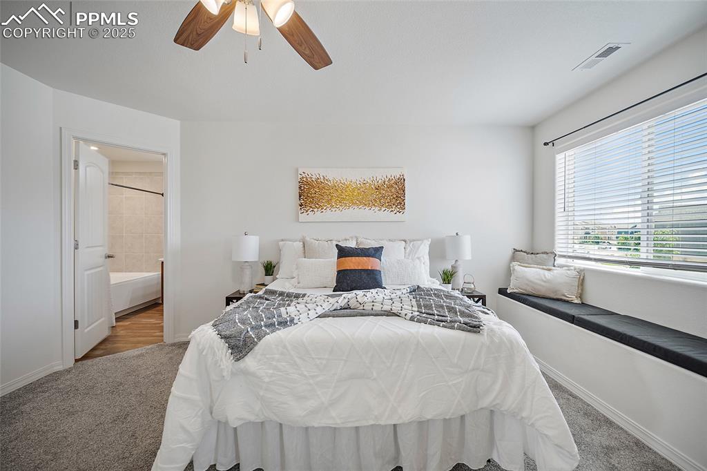 Image 30 of 50: Carpeted bedroom with a ceiling fan and ensuite bathroom