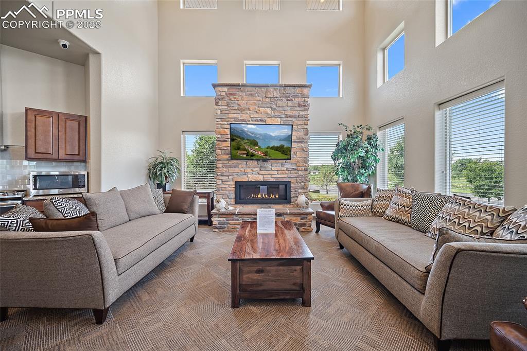 Image 34 of 50: Living room with a towering ceiling and a fireplace