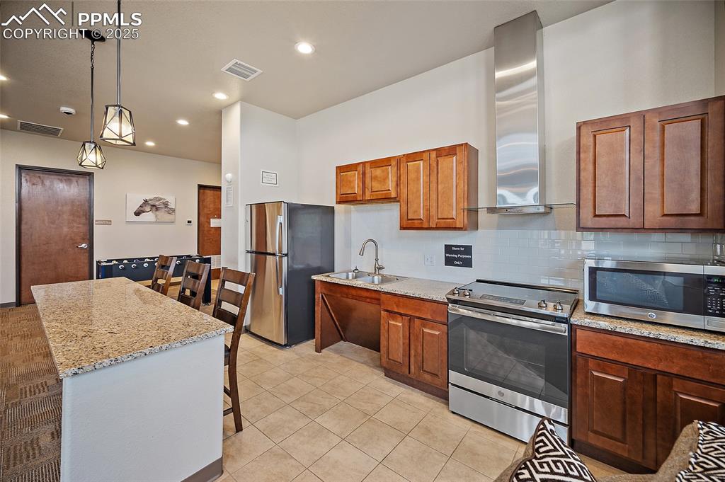 Image 36 of 50: Kitchen with appliances with stainless steel finishes, decorative backsplas