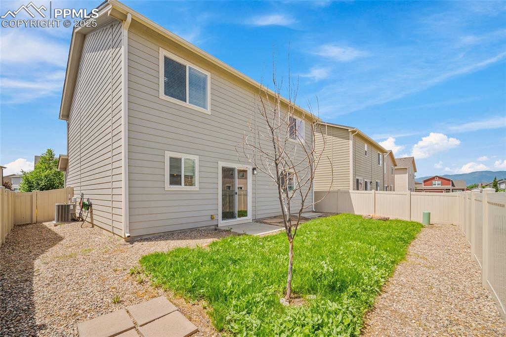 Image 8 of 50: Back of house with a fenced backyard