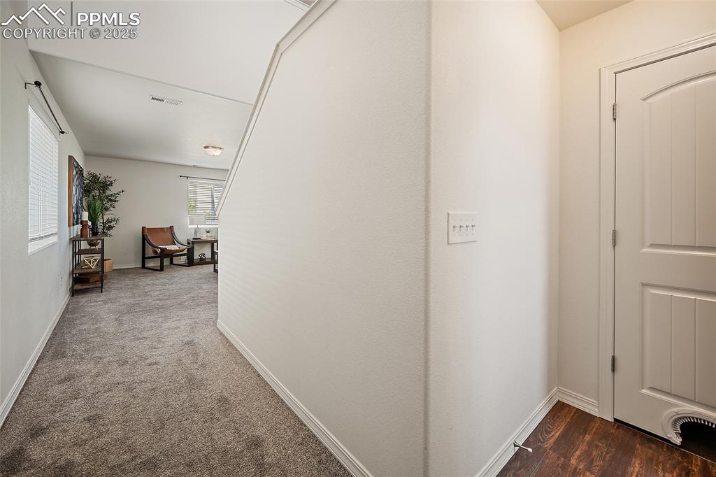 Image 9 of 50: Hall with baseboards and carpet flooring