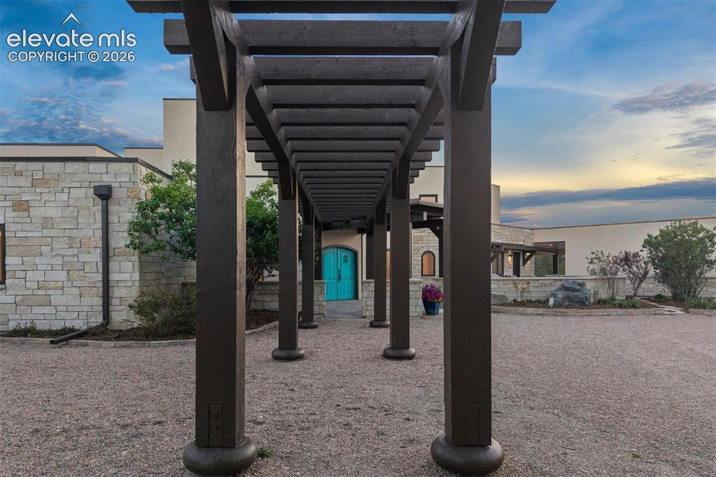 Image 11 of 46: Pergola pathway leads to the symbolic, arched turquoise doors.