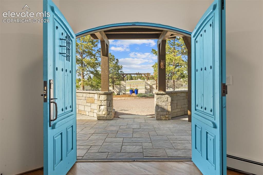 Image 12 of 46: Custom double-arch solid wood entry doors commissioned from VML Custom Wood