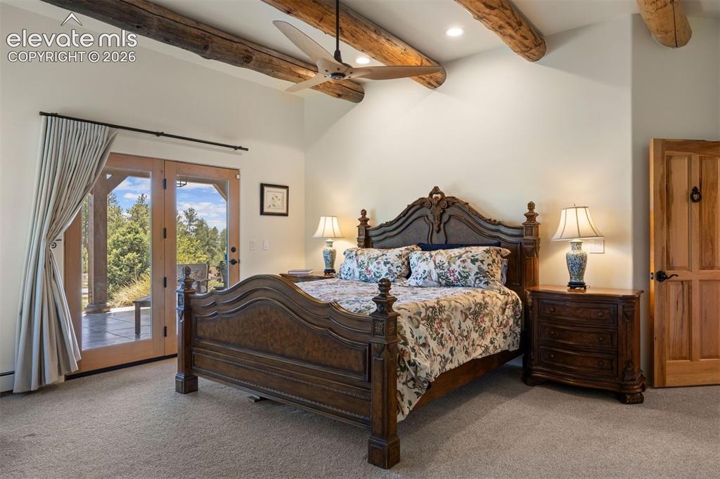 Image 21 of 46: Primary suite with natural hand-hewn beams, glass door walk out to a privat