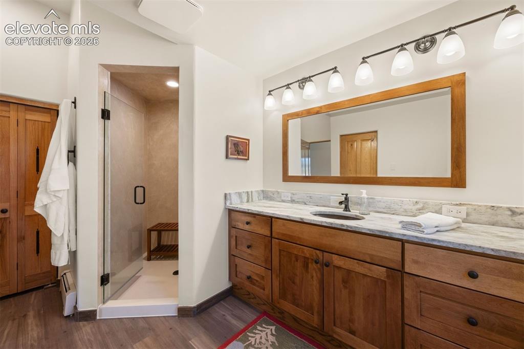 Image 24 of 46: Primary suite with generous walk-in shower with glass enclosure and bench s