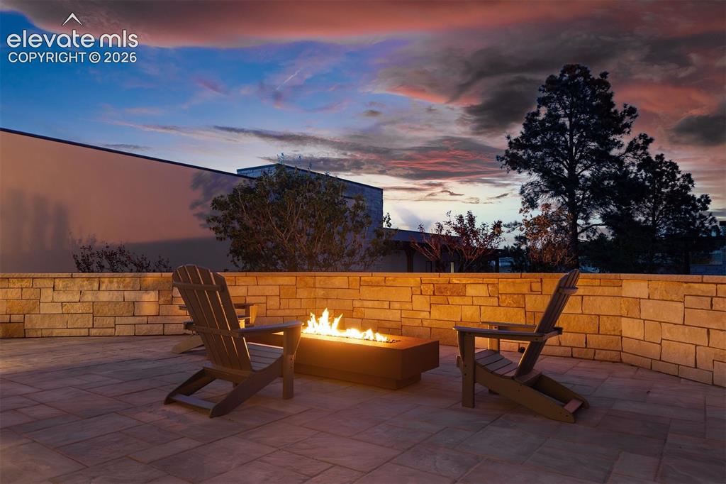 Image 28 of 46: Stunning courtyard patio with a sleek linear Corten steel gas fire pit fram