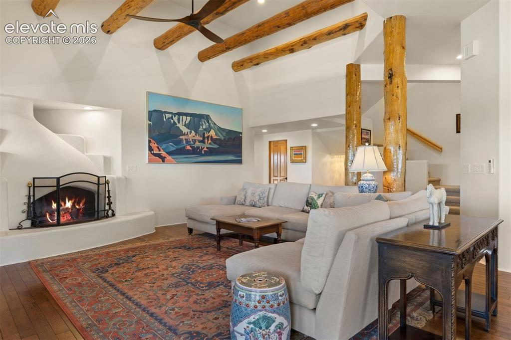Image 4 of 46: The great room showcases a 14-foot ceiling with hand-hewn log beams, natura