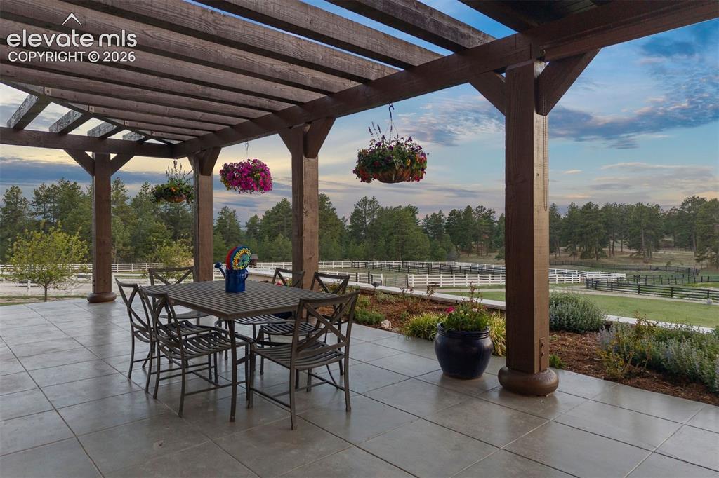 Image 5 of 46: Magnificent outdoor living with expansive wraparound patio with pergolas an