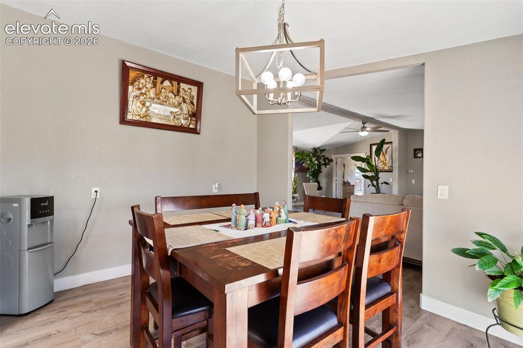 Image 12 of 34: Dining area featuring wood-finish flooring, a contemporary chandelier, and 
