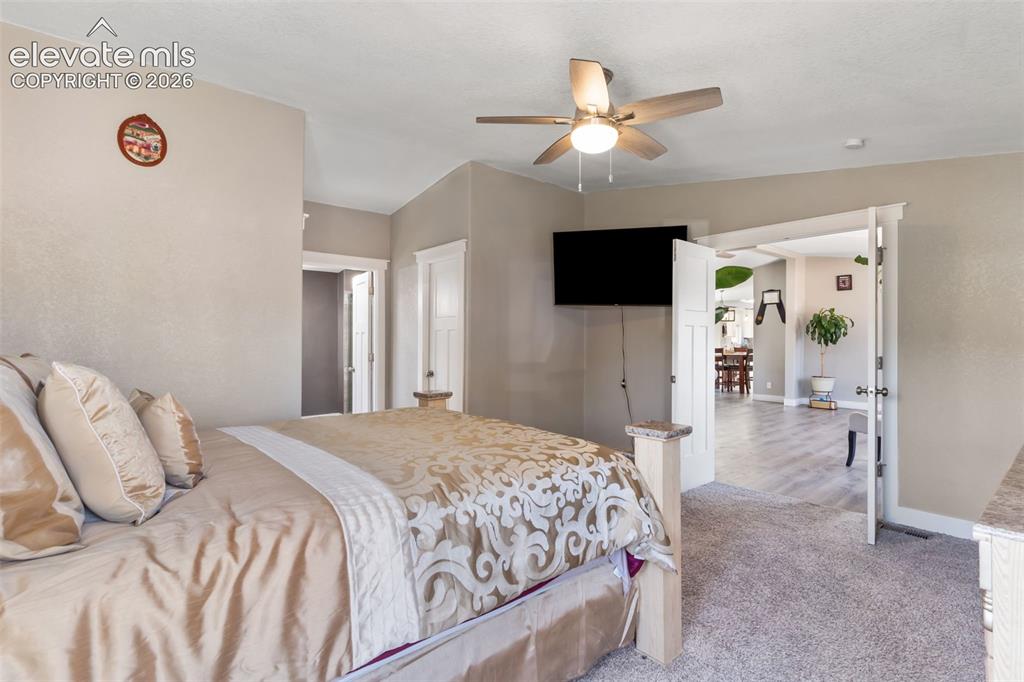 Image 20 of 34: Carpeted room featuring a ceiling fan with integrated lighting, a wall-moun