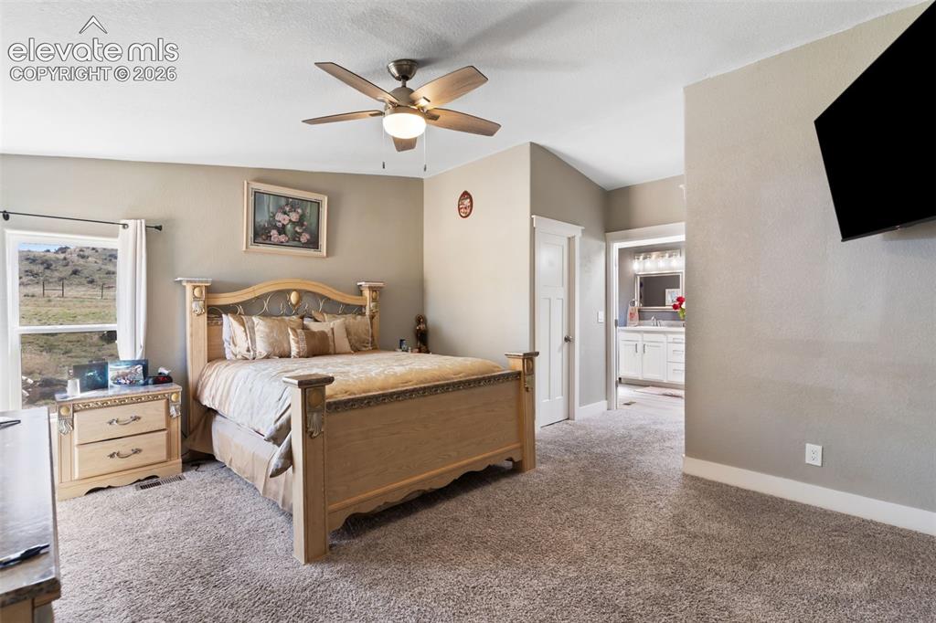 Image 22 of 34: Carpeted room featuring a ceiling fan with integrated lighting, a window wi