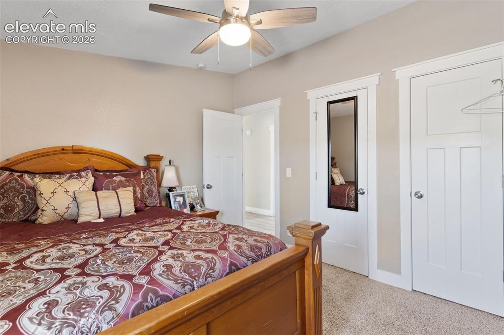 Image 24 of 34: Neutral-toned bedroom featuring plush carpet flooring