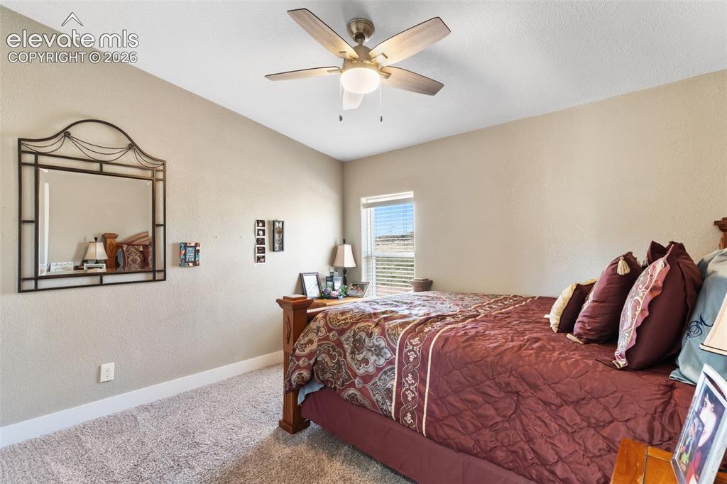Image 25 of 34: Carpeted room featuring a ceiling fan with integrated lighting, a single wi