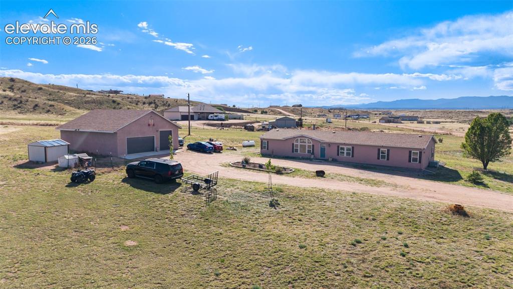 Image 5 of 34: Expansive property featuring a single-story home with a light-colored exter
