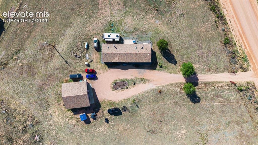 Image 6 of 34: Expansive property featuring two structures with shingle roofs, a gravel dr