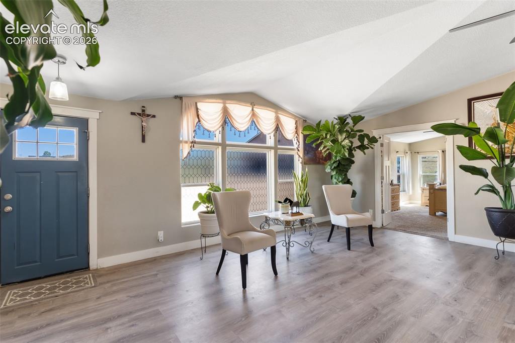 Image 7 of 34: Entry area featuring wood-finish flooring, a blue front door with upper lit