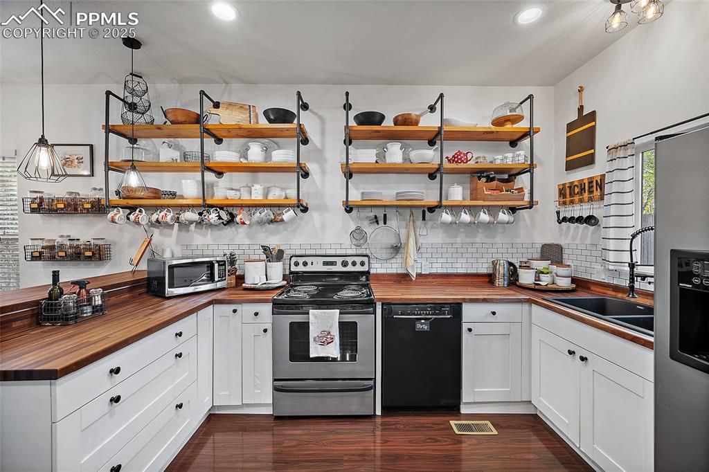 Image 10 of 36: Dining area featuring dark wood-type flooring and a ceiling fan