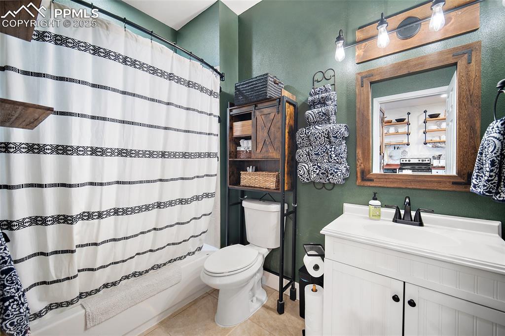 Image 20 of 36: Kitchen featuring wood counters, decorative light fixtures, white cabinets,