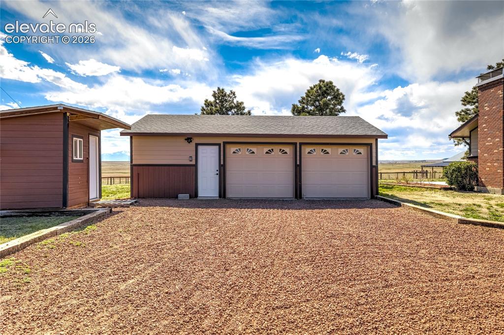 Image 10 of 50: 2 car garage with shop area, chicken coop to left.