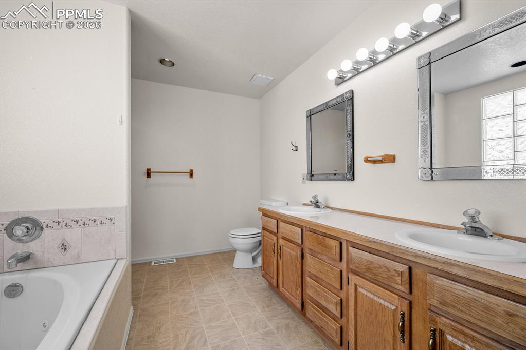 Image 14 of 38: Bathroom with a garden tub and double vanity