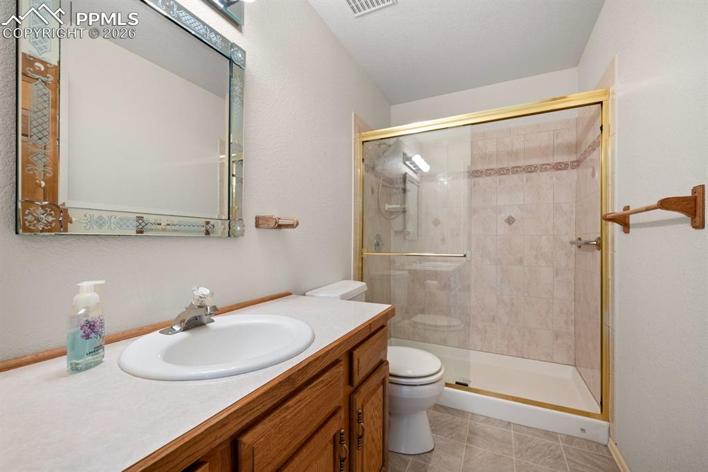 Image 18 of 38: Full bath featuring vanity, a shower stall, light tile patterned floors, an