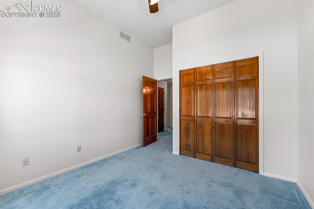 Image 21 of 38: Unfurnished bedroom with carpet floors, ceiling fan, a closet, and a high c