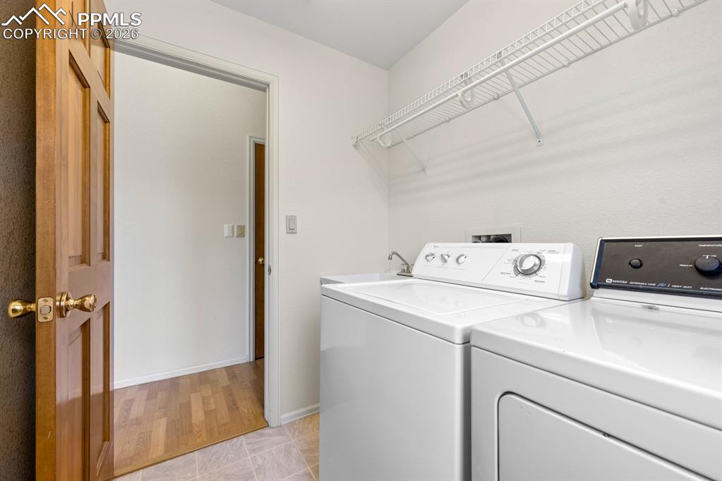 Image 23 of 38: Laundry area with separate washer and dryer and light tile patterned floori